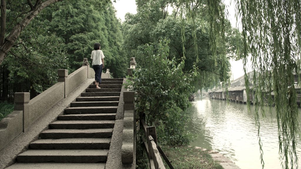 Person walking on staircase next to waterway