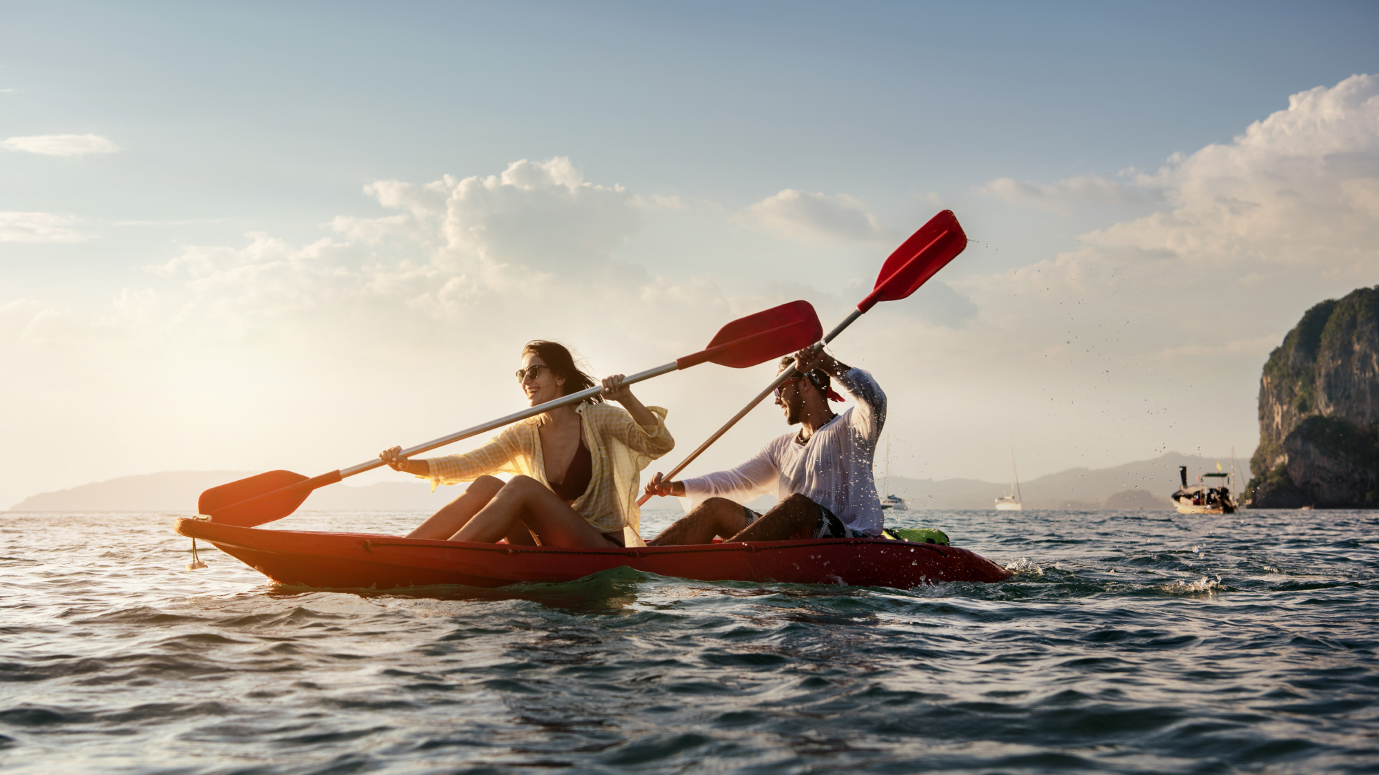 couple enjoying themselves kayaking in the ocean smiling