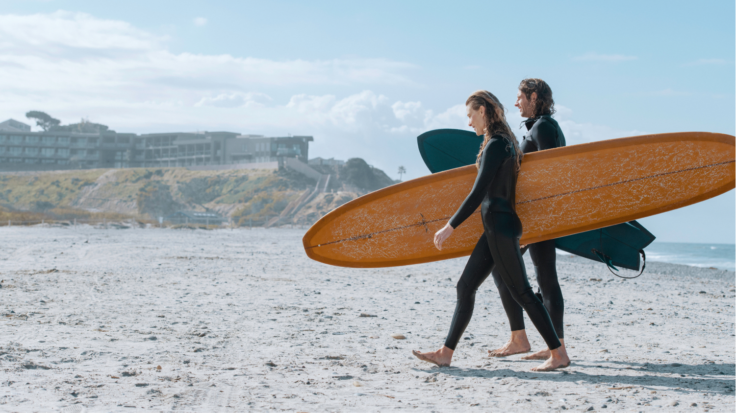 couple carrying surf board