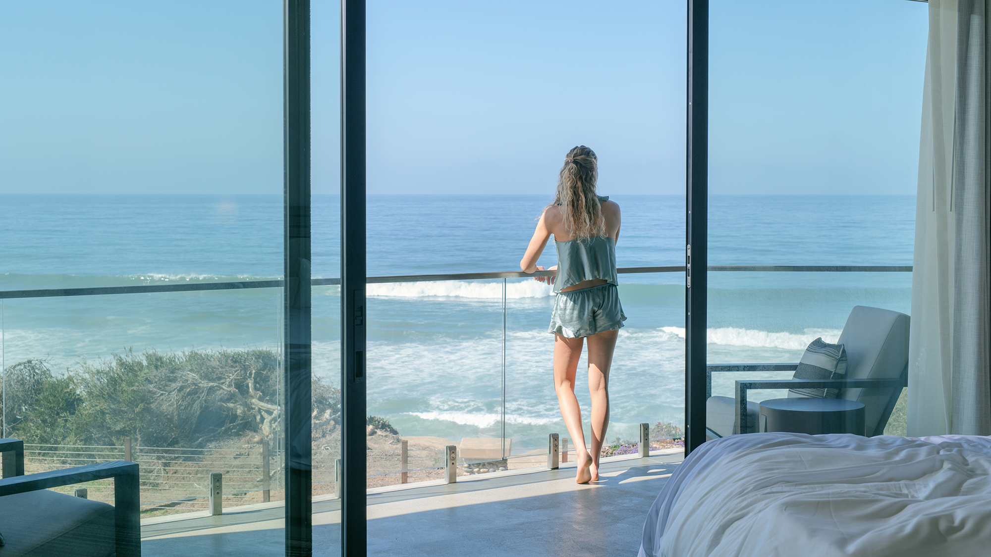 Woman on ocean view resort balcony
