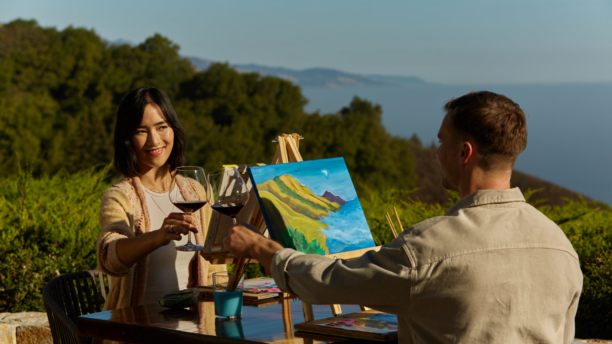 couple participating in private painting experience while drinking wine