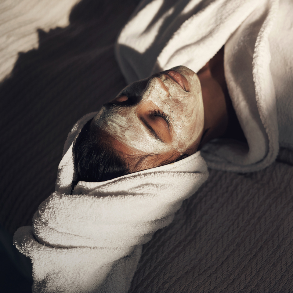 person with face mask relaxing at the spa