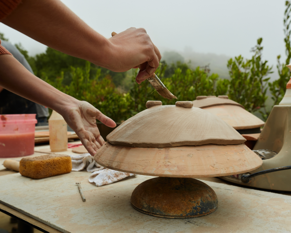 person molding ceramic object