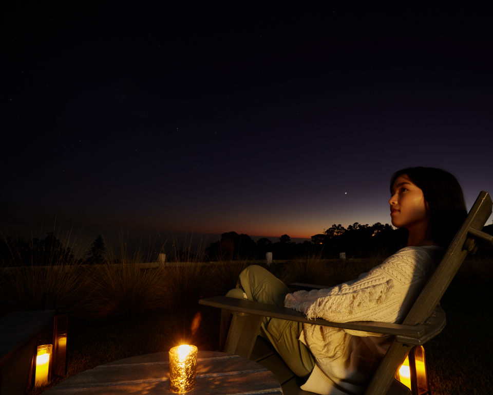 person sitting and looking at the stars
