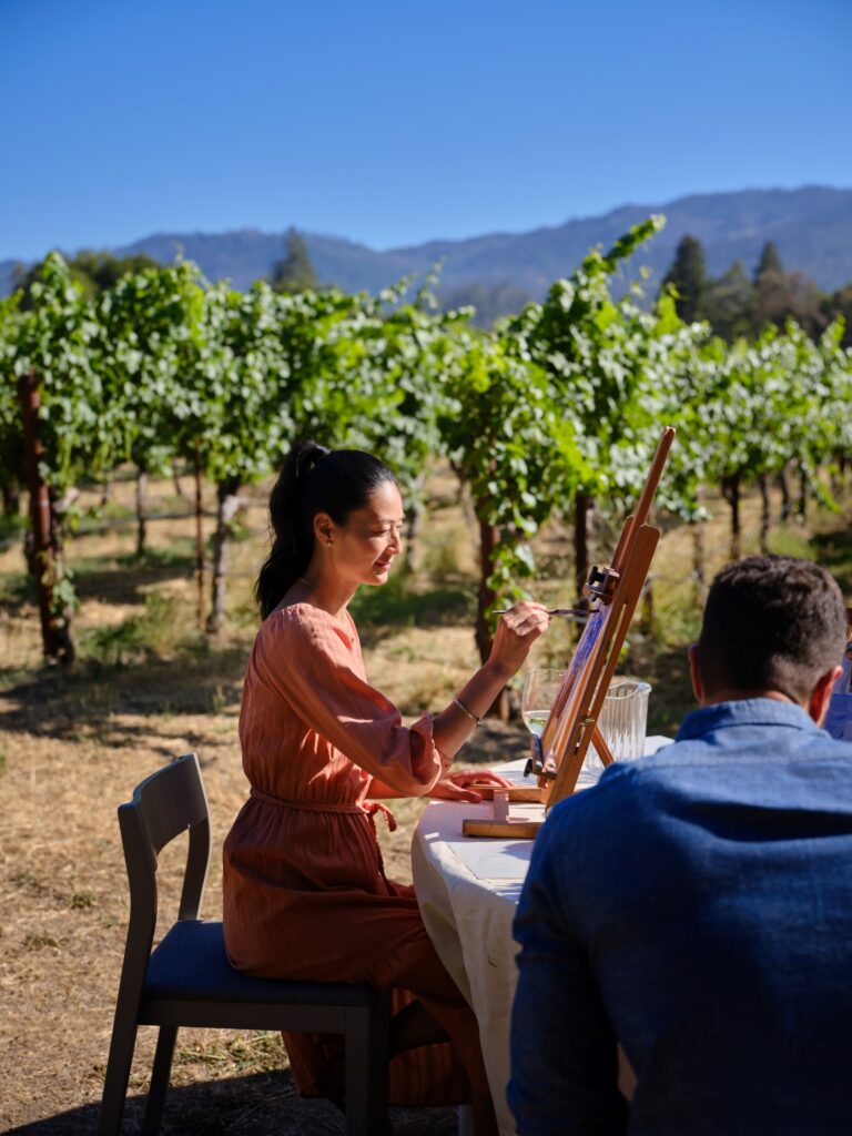 Woman painting in the vineyards adjacent to Alila Napa Valley