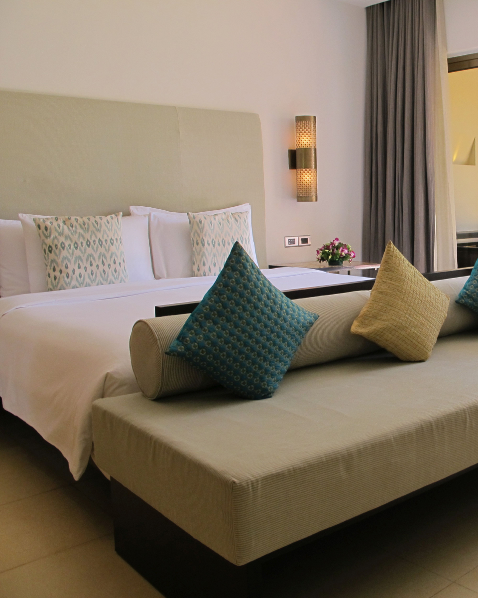 interior hotel room with neutral colors and accent pillows