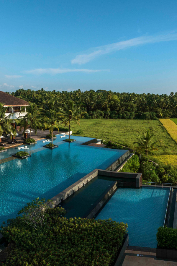 hotel pool with green fields and trees in the background