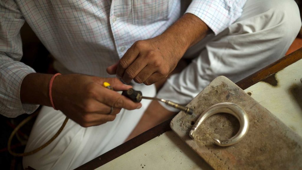 person sitting criss crossed holding a tool