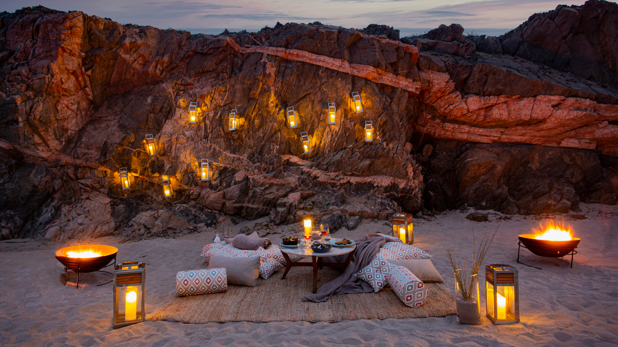 intimate dinner set up on the beach at dusk