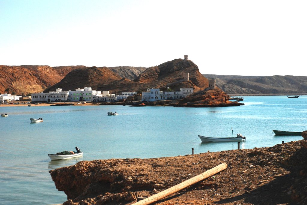 View of floating boats in the lagoon with the rocks and hills in the background