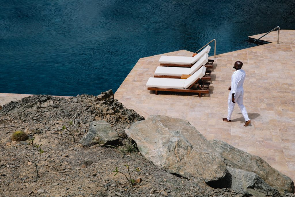 person walking to loungers with ocean views