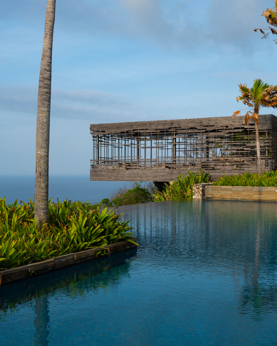Faraway shot of covered patio with infinity pool in the foreground