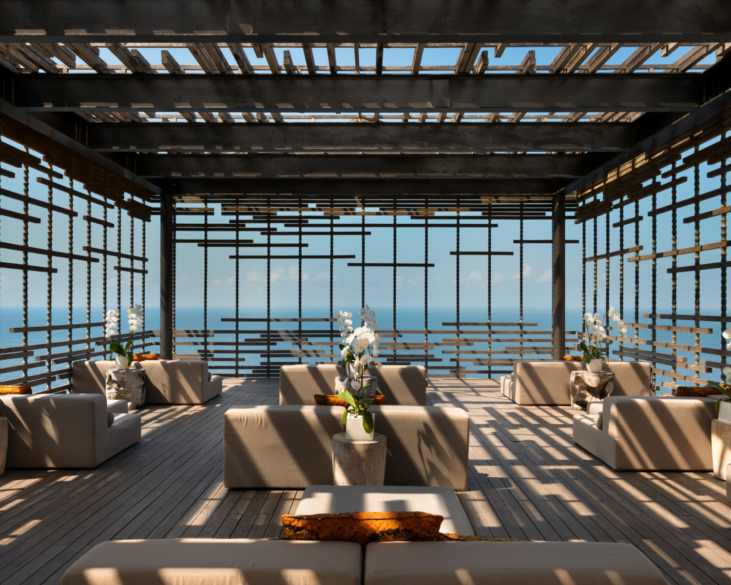 Sunset cabana couches on a patio overlooking the ocean.