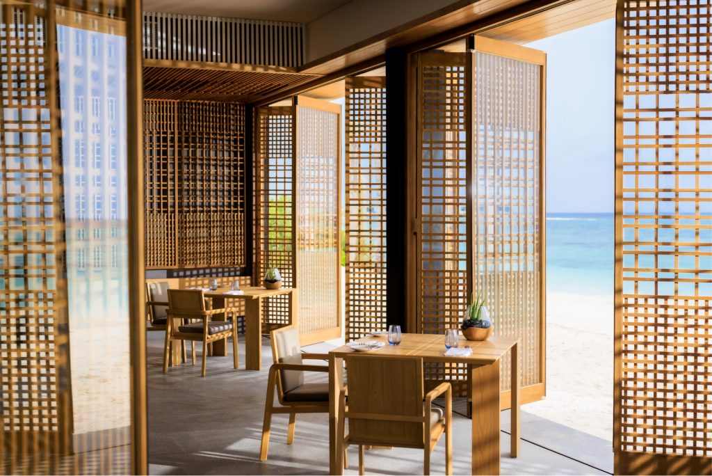 Wooden dining tables with an ocean view and wooden panels