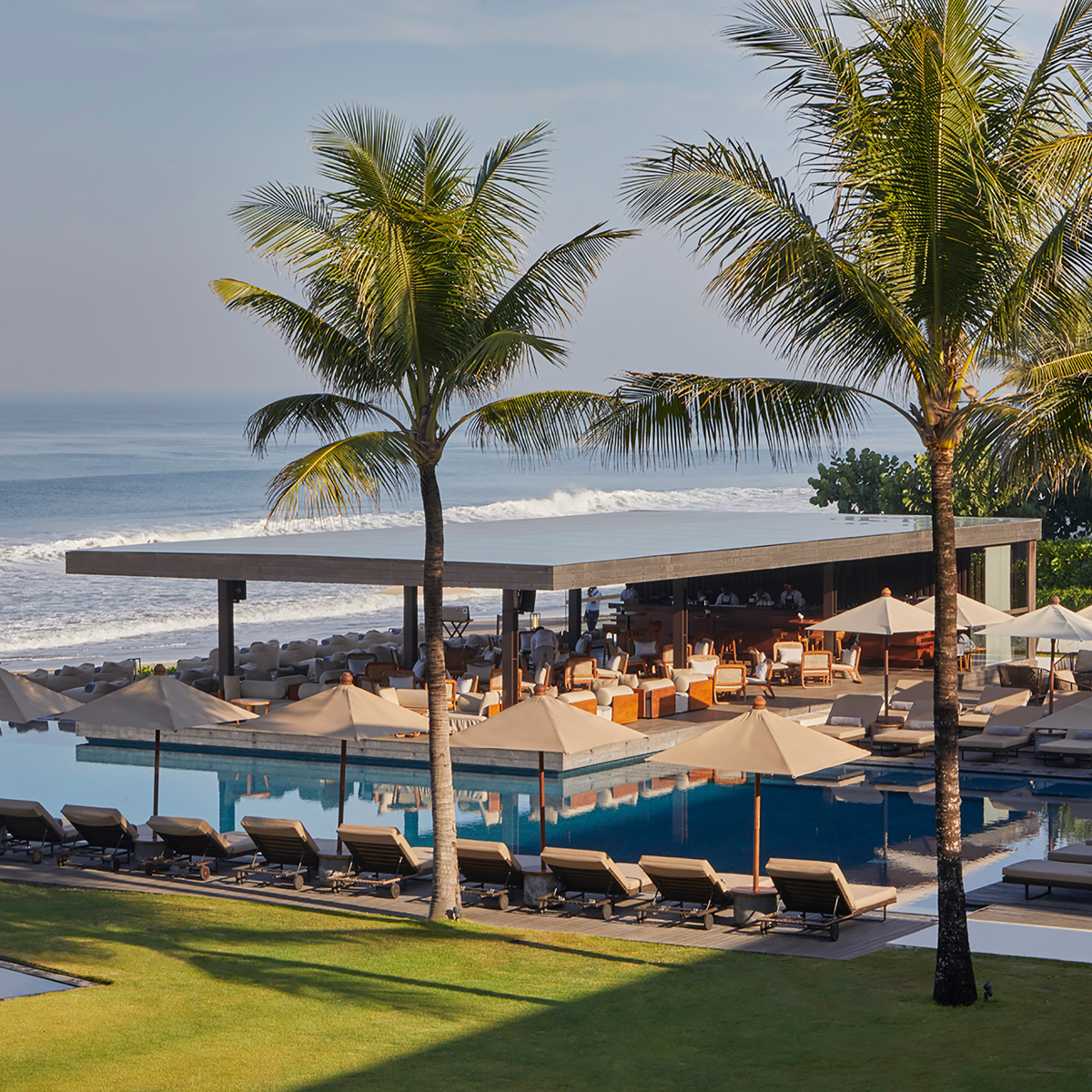 Pool with lounge chairs, umbrellas and an ocean view