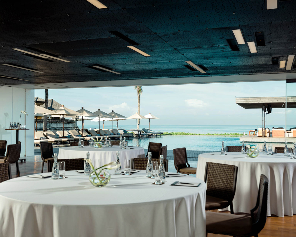 Round tables with white table cloth by the poolside