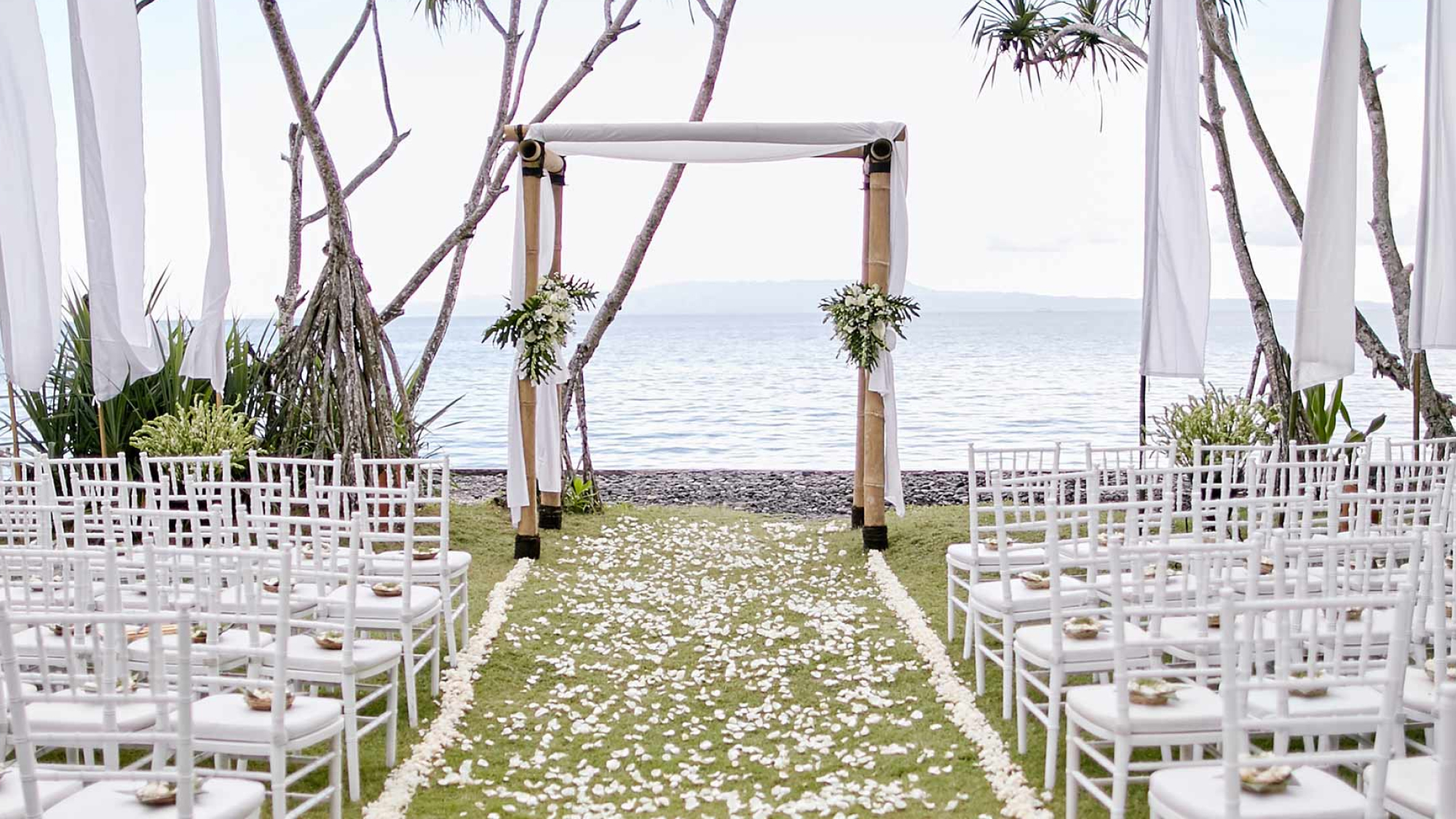 Wooden arch, decorated with white flowers at wedding ceremony