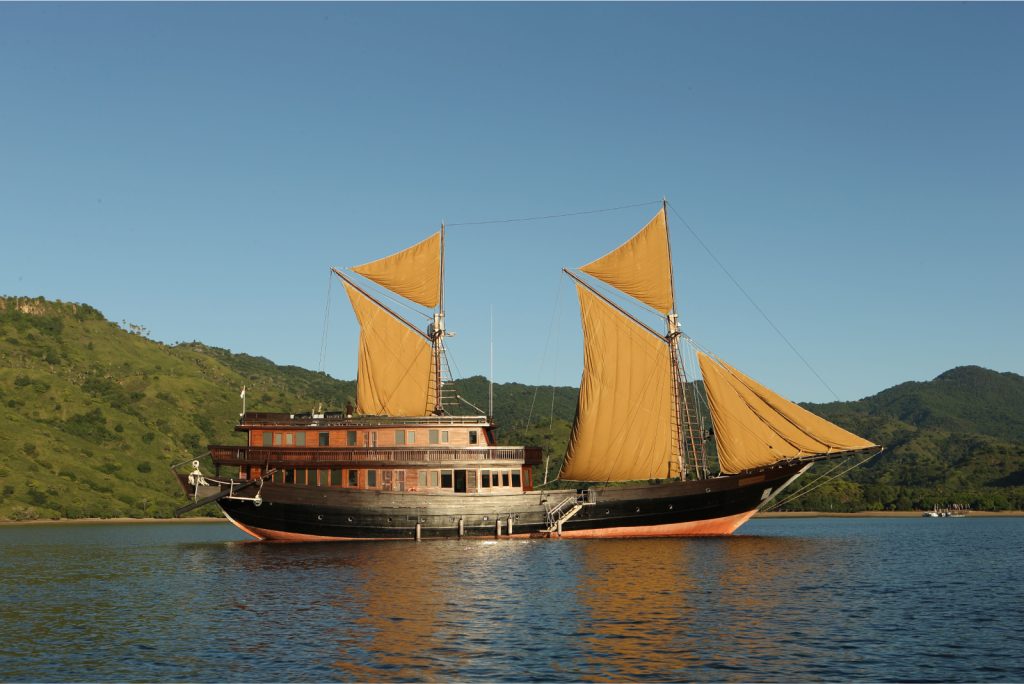 Purnama boat in calm water with open sails