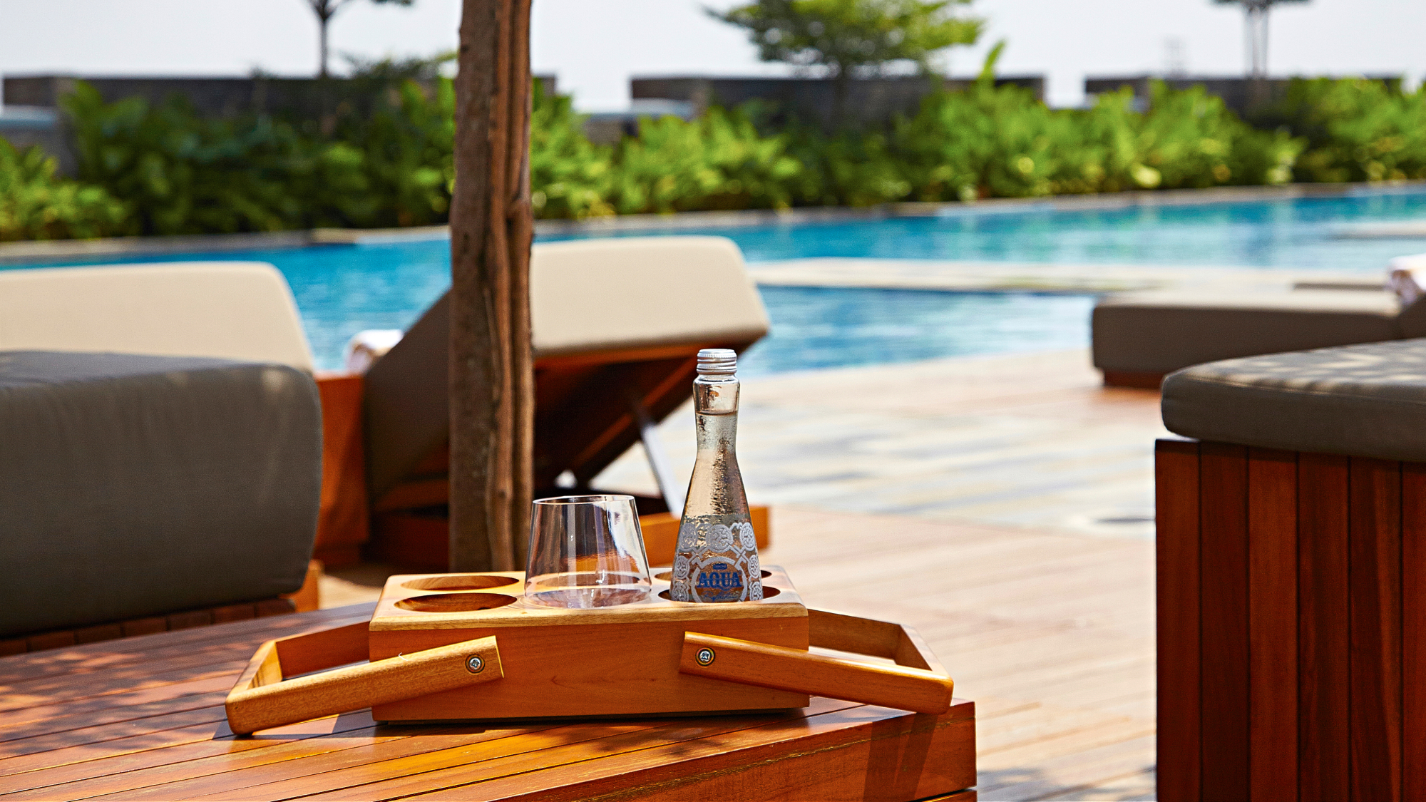 poolside view of lounge chairs and drink bottle