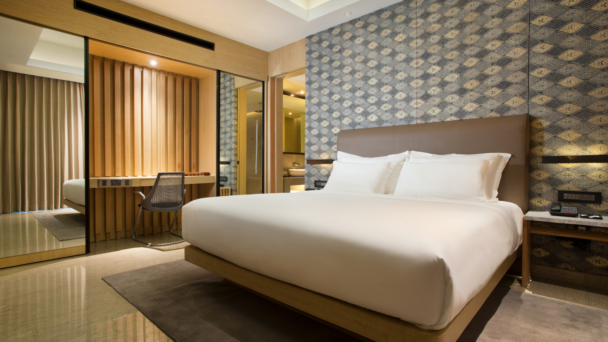 interior of hotel room with large bed and side table