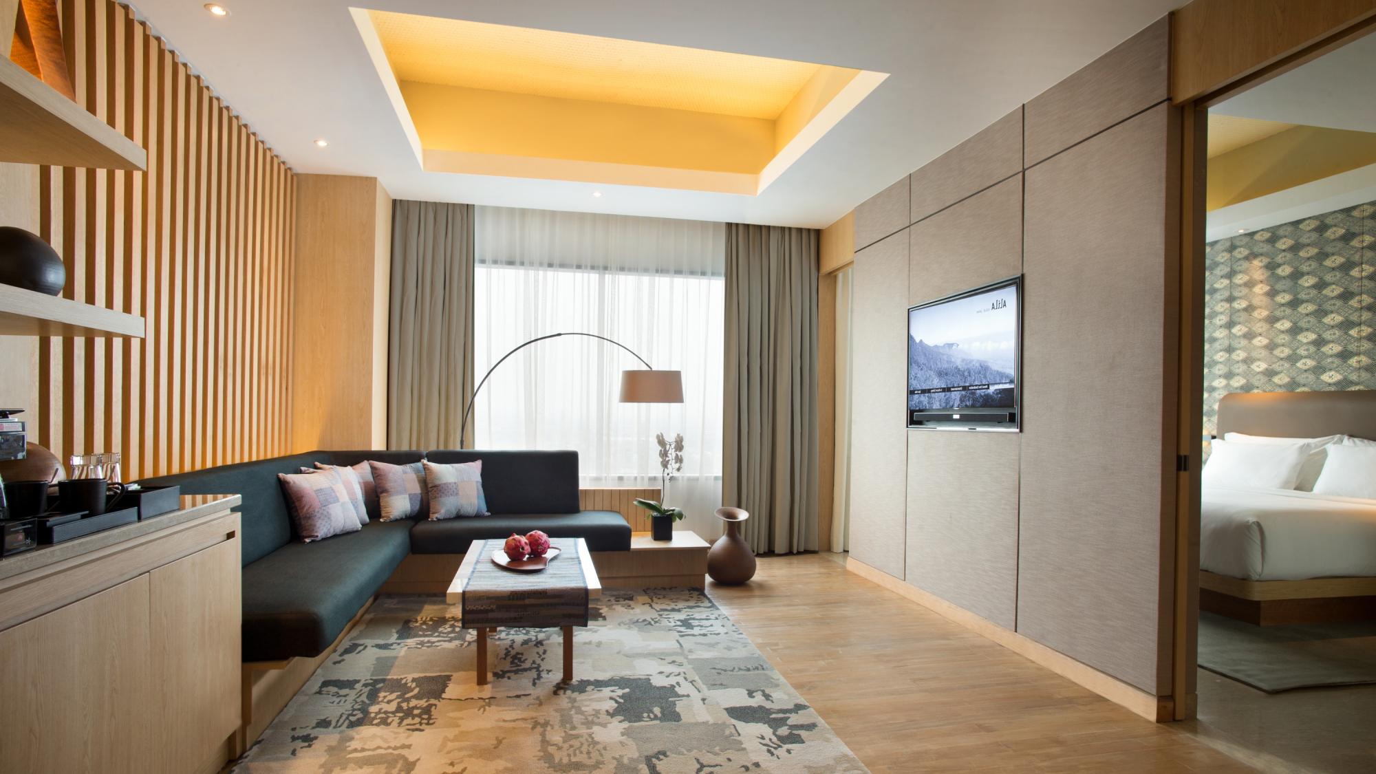 hotel room with green couch, coffee table and overhead lamp