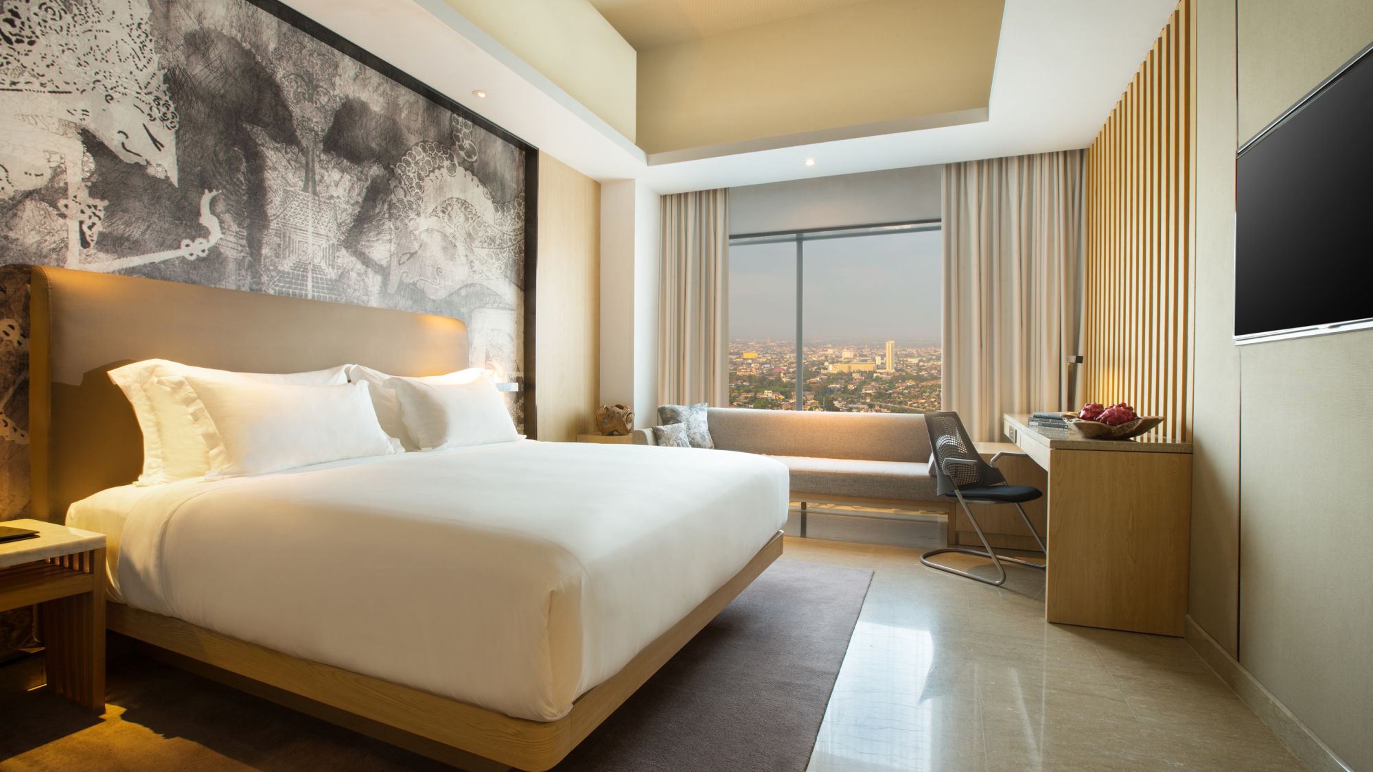 interior hotel room with large bed and view of city